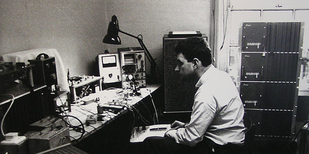 Schwarzweiß Foto von Ray Dolby vor technischen Aufbauten