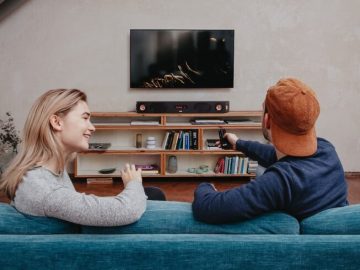 Mann und Frau auf dem Sofa vor dem Fernseher mit Teufel Soundbar