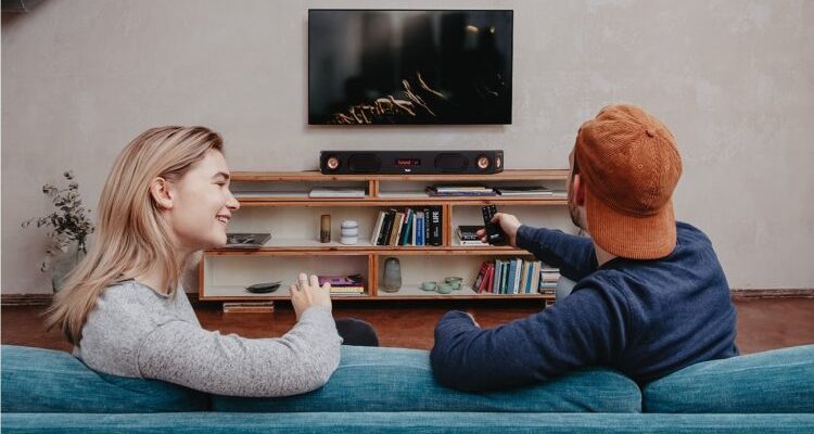 Mann und Frau auf dem Sofa vor dem Fernseher mit Teufel Soundbar