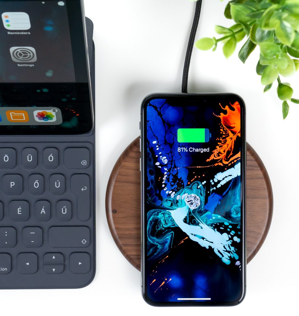 Oplader met houten design laadt smartphone op.
