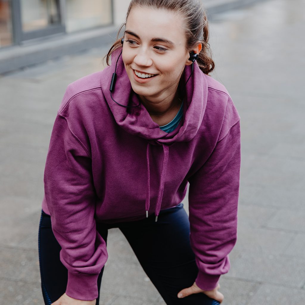 Frau hört Podcasts beim Sport.