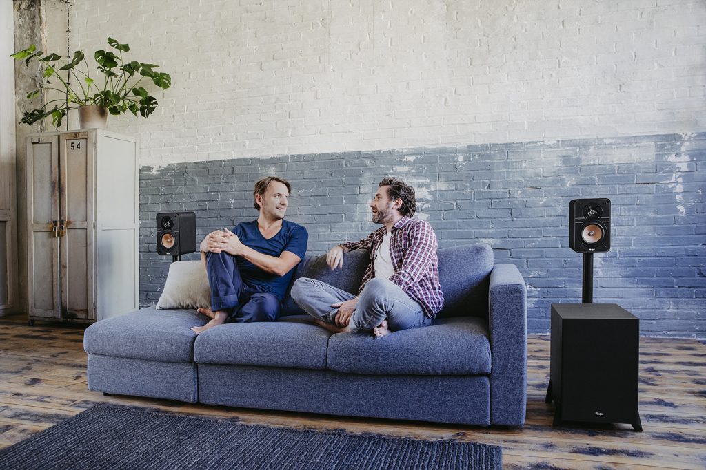 Zwei Freunde unterhalten sich im Wohnzimmer.