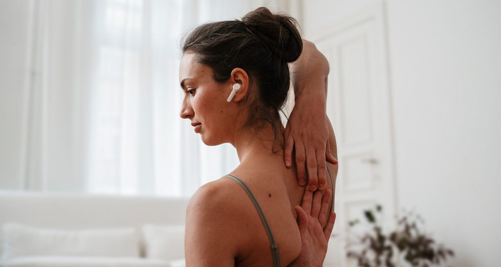 Frau mit Kopfhörer beim Yoga