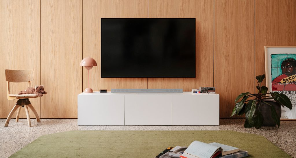 Zusehen ist ein Wohnzimmer mit Sideboard, Soundbar und TV.