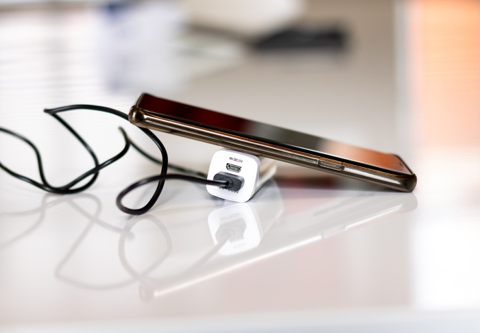 Hand und Powerbank durch Kabel verbunden