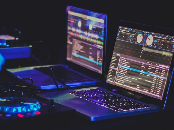 DJ-Set-up mit Controller und 2 Macbooks, auf denen eine DJ-Software läuft.