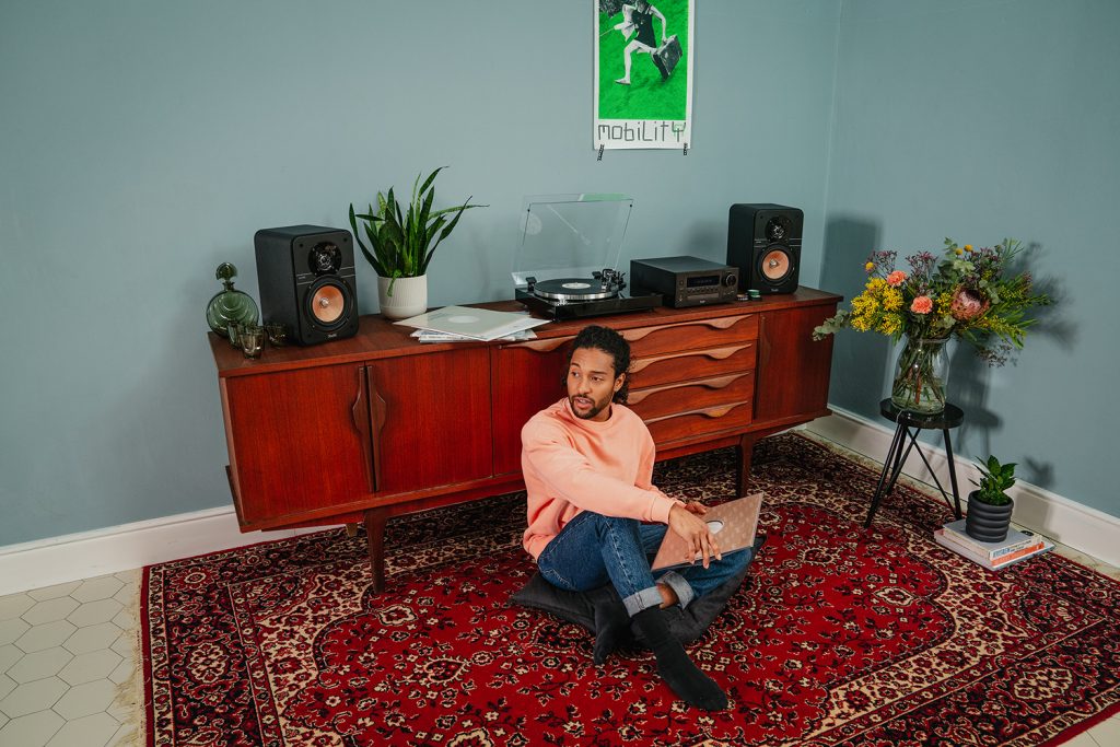 Man listening to records with Teufel ULTIMA 20 speakers while sitting on carpet