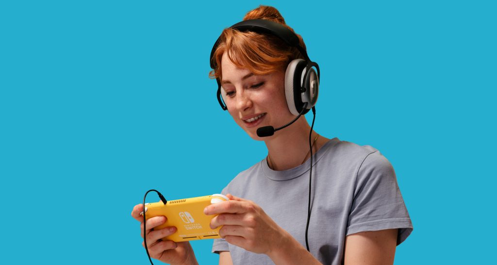 Frau trägt ZOLA Headset von Teufel, das per Kabel an eine Nintendo Switch Lite angeschlossen ist
