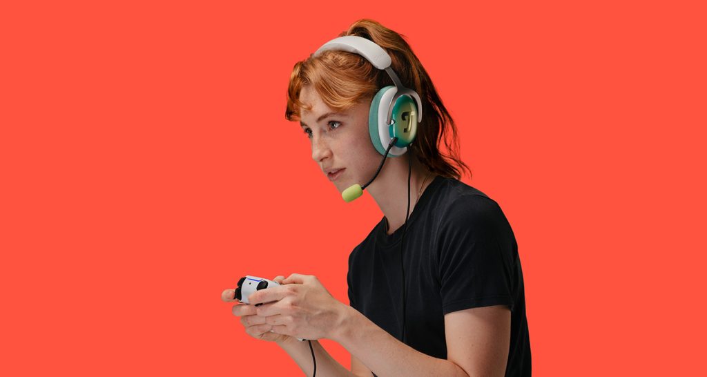 Junge Frau mit Controller trägt Gaming-Headset Zola von Teufel