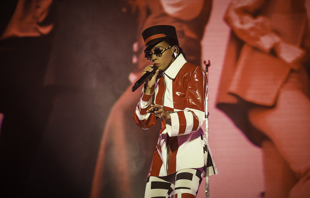 Janelle Monáe auf der Bühne in rot-weißem Outfit und Zylinderhut.