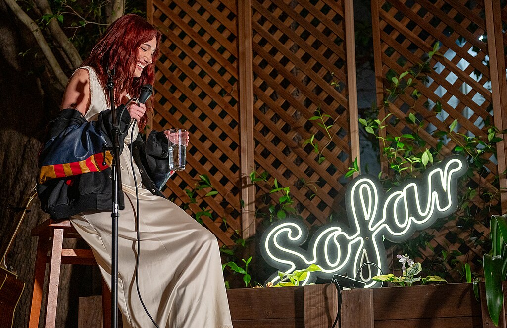 Sängerin sitzt auf einem Hocker bei einer Sofar-Sounds-Show.