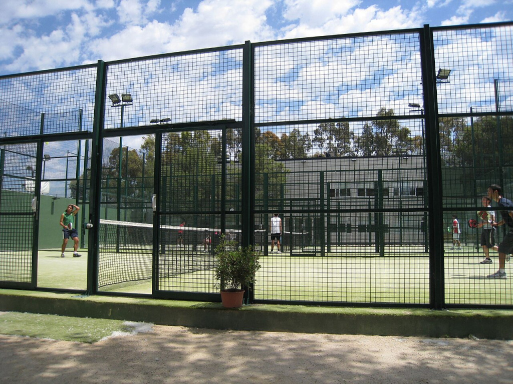 Outdoor-Padel-Court mit Gitterwänden während eines Spiels