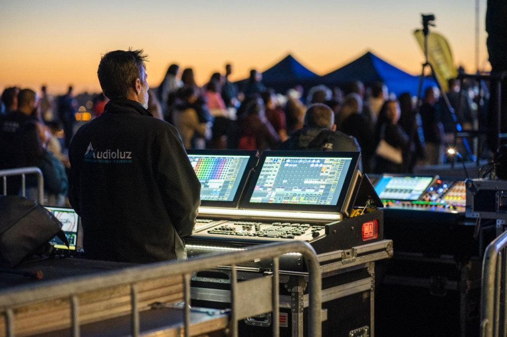 Mischpult und Veranstaltungstechnik bei einem Open-Air-Konzert im Sonnenuntergang.